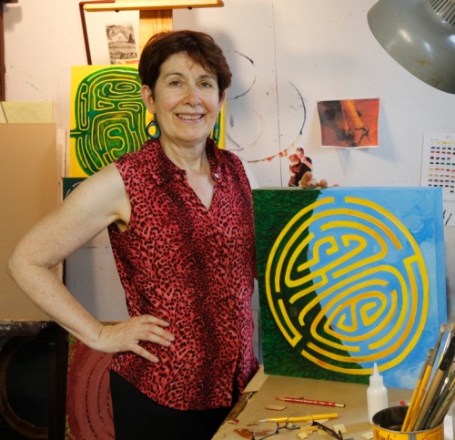Lesley Mitchell in studio with painting, Golden Maze with Houses